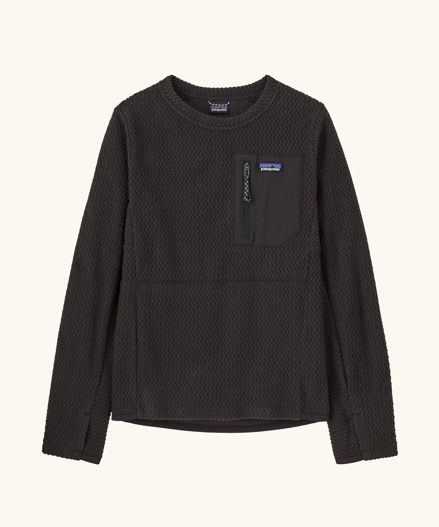 Patagonia Kids R1 Air Crew in Black. Ribbed textured body with square zipped pocket on the chest, and thumb holes.