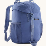 Patagonia kids refugio 12 litres backpack in dark and light blue available at Babipur.. Features padded shoulders, 2 side pockets and a flip lid with a buckle fastener. 
