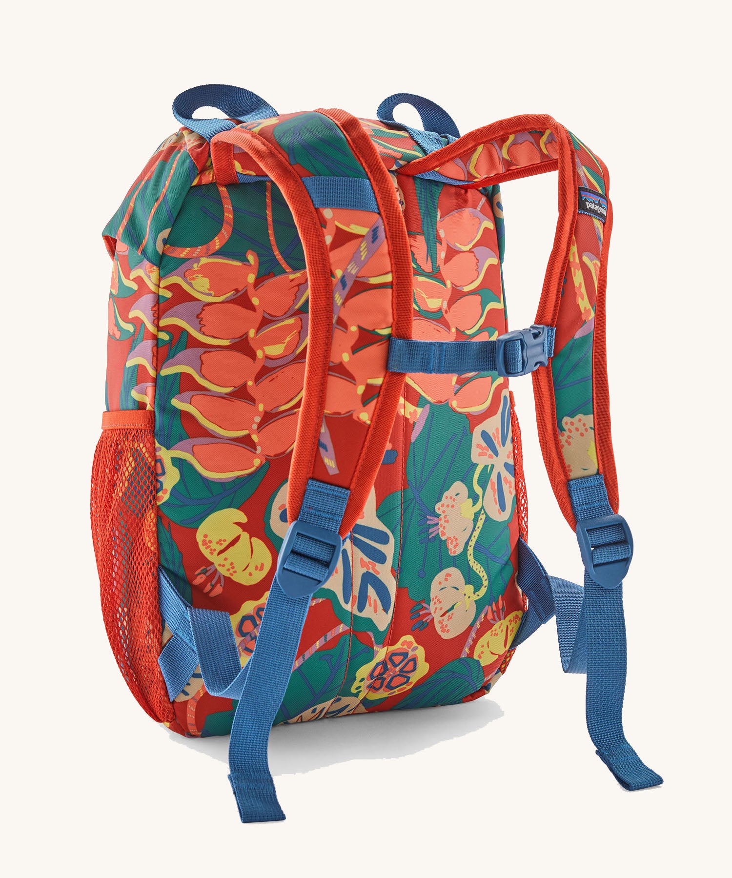 Patagonia kids refugito 12L day pack in red with a repeating tropical flower design. Shows shoulder straps with blue buckle 