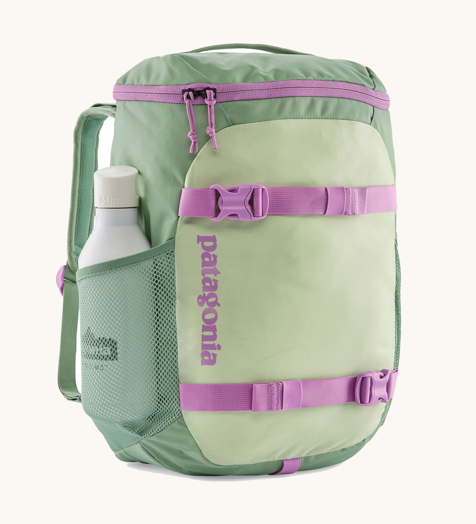 Patagonia refugito 18 litres daypack in ellwood green. A pastel green backpack with 2 side mesh pockets, pink buckle, fasteners on the front to keep it secure and a zip on the top for easy access with padded shoulder straps.