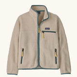 Patagonia Kids Retro Pile Jacket in Dark Natural. Cream fleece body with light sage green binding and zip pockets with pale yellow details.