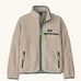 Patagonia Kids Retro Pile Jacket in Dark Natural. Cream fleece body with light sage green binding and zip pockets with pale yellow details.