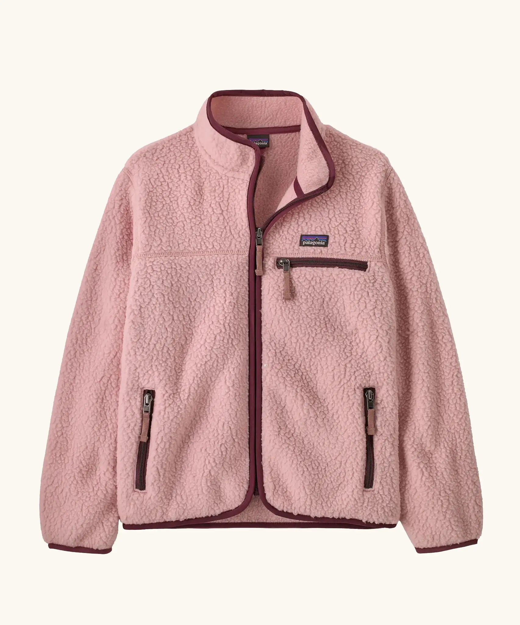 Patagonia Kids retro pile jacket in Fuzzy Mauve. Light pink fleece with maroon binding and contrasting zip pockets.