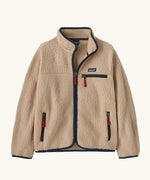 Patagonia Kids Retro Pile Jacket in Valley Khaki. Cream fleece body with Navy blue binding and zip pockets with red details.