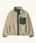 Patagonia Kids Retro X Fleece Jacket in Dark Natural with Canopy Green. Cream fleece with contrasting forest green binding, collar and square chest pocket.