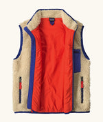 An open Patagonia kids retro x vest in dark natural showing pile fleece outer and bright orange inner lining