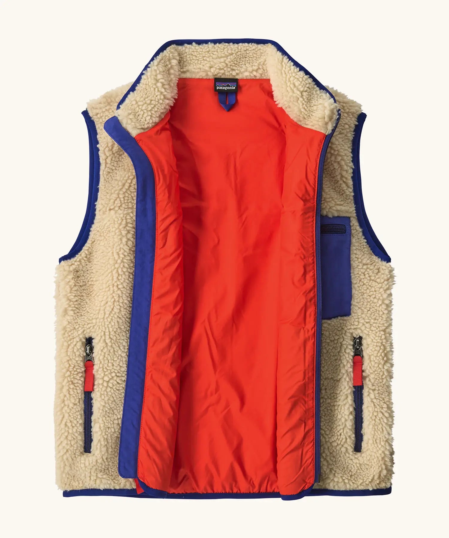 An open Patagonia kids retro x vest in dark natural showing pile fleece outer and bright orange inner lining