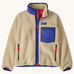 Patagonia kids retro x jacket in dark natural available at Babipur.. A 100% recycled polyester thick pile fleece in cream with blue trim. Features a turn up collar, full length zip , 2 side pockets and a chest pocket.