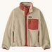 Patagonia kids retro x jacket in dark natural/potters red available at Babipur.. A 100% recycled polyester thick pile fleece in cream with pale red trim. Features a turn up collar, full length zip, 2 side pockets and a chest pocket.