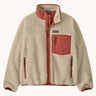 Patagonia kids retro x jacket in dark natural/potters red available at Babipur.. A 100% recycled polyester thick pile fleece in cream with pale red trim. Features a turn up collar, full length zip, 2 side pockets and a chest pocket.