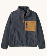 Patagonia kids synchilla fleece jacket in smolder blue available at Babipur. A 100% recycled polyester soft fleece in dark blue with matching trim. Features a turn up collar, full length zip 2 side pockets and a zip chest pocket with yellow panel