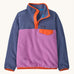 Patagonia kids synchilla pullover fleece in brisk purple. A light fleece in pastel and light purple with orange trim. Features popper fasteners and a chest pocket in yellow