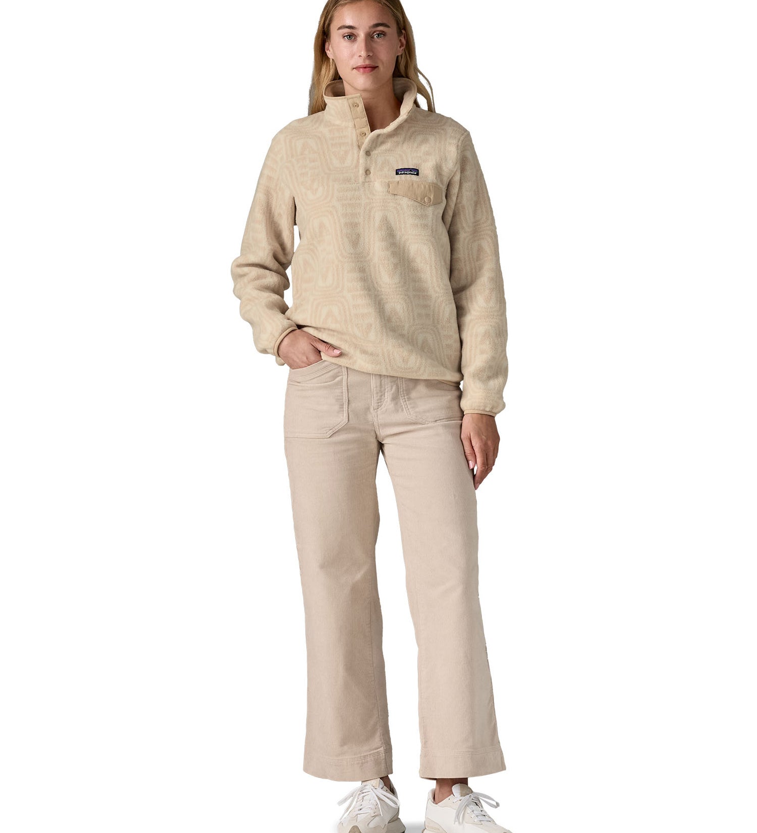 A woman wearing the Patagonia women's synchilla jacket in flow dyno white available at Babipur. 