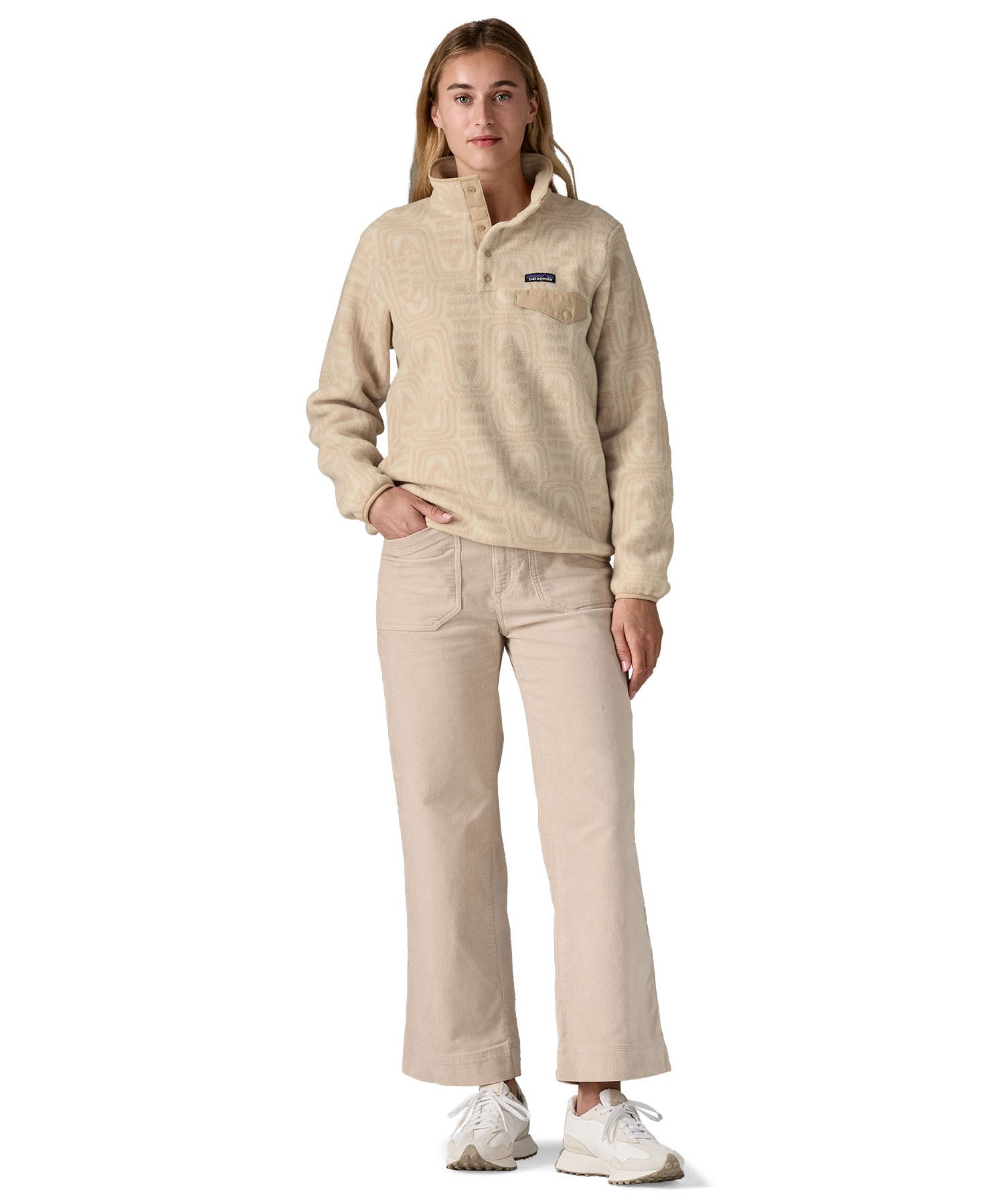 A woman wearing the Patagonia women's synchilla jacket in flow dyno white available at Babipur. 