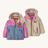 Patagonia little kids tribbles hoody. A reversible coat showing a blue and green hooded coat and natural fleece alternative side. Features a small chest pocket and side pockets