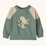 Patagonia 100% organic cotton little kids crew sweatshirt in pale green with beige shoulder panels. Showing a playful rabbit print on the front.
