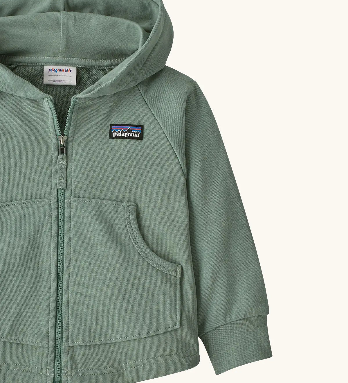 Patagonia 100% organic cotton little kids full zip hoody in pale green showing close up of the pouch pocket on the front