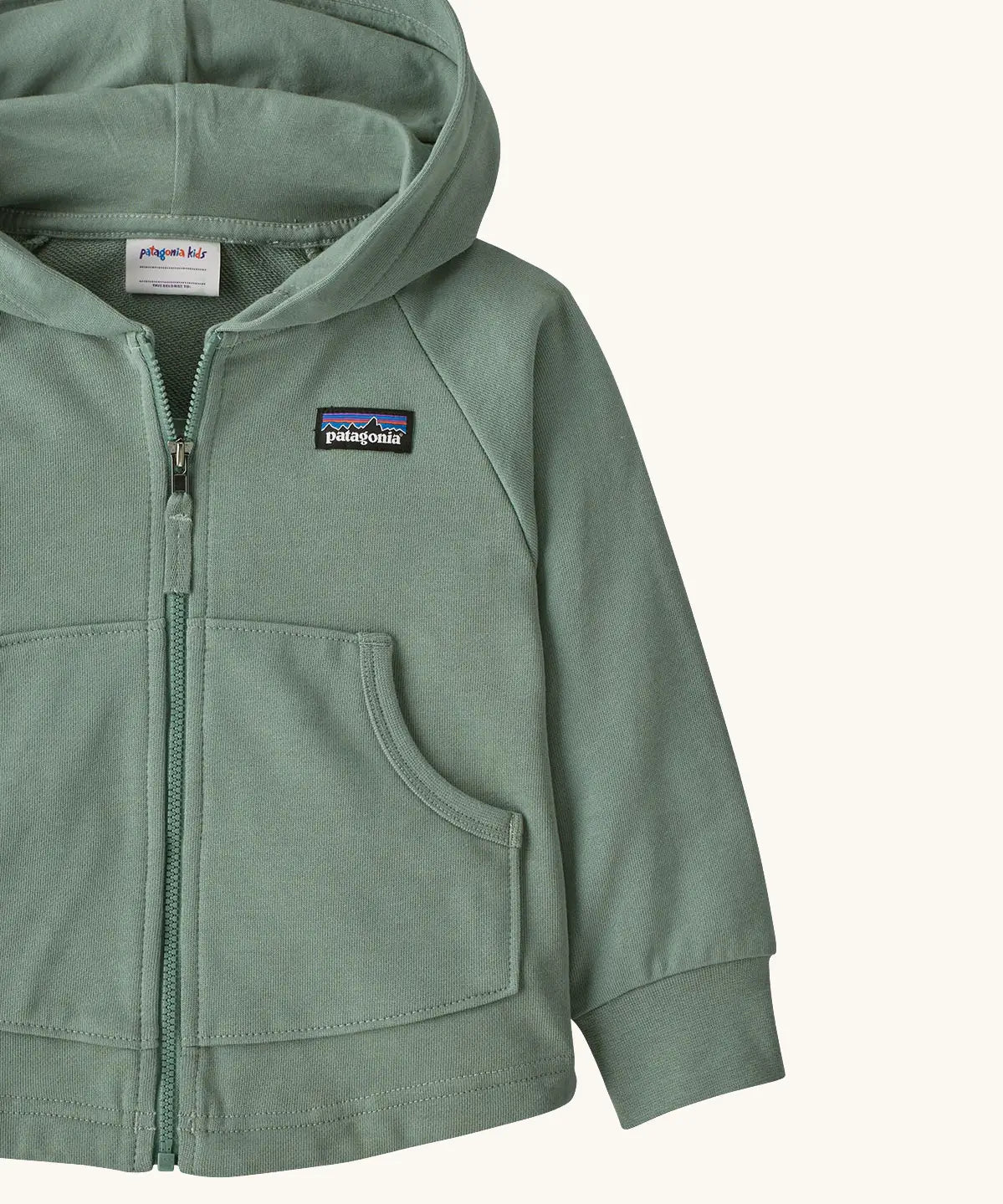 Patagonia 100% organic cotton little kids full zip hoody in pale green showing close up of the pouch pocket on the front
