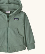 Patagonia 100% organic cotton little kids full zip hoody in pale green showing close up of the pouch pocket on the front