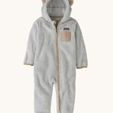 Patagonia little kids furry fiends bunting suit in crisp grey available at Babipur. A 100% recycled polyester thick fleece all in one in light grey with light brown trim and matching bear like ears on the hood. Features a full length zip, elasticated cuffs and a small chest pocket