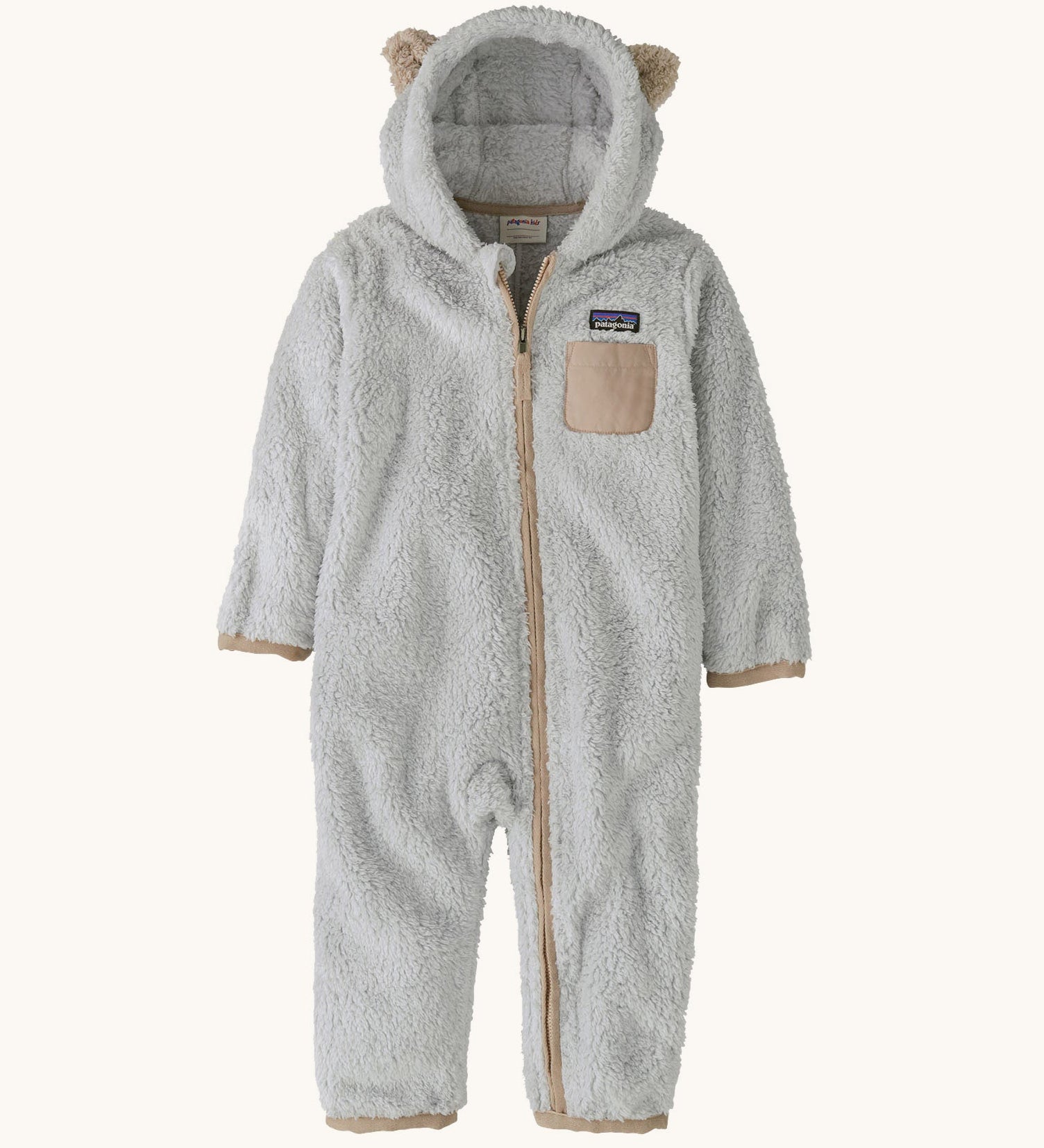 Patagonia little kids furry fiends bunting suit in crisp grey available at Babipur. A 100% recycled polyester thick fleece all in one in light grey with light brown trim and matching bear like ears on the hood. Features a full length zip, elasticated cuffs and a small chest pocket