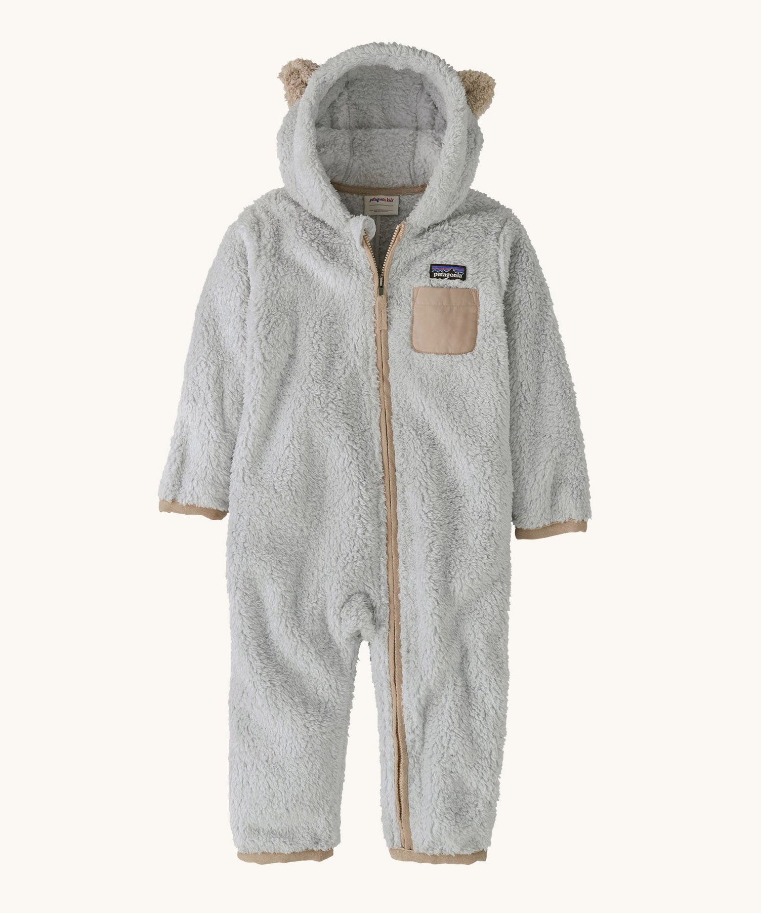 Patagonia little kids furry fiends bunting suit in crisp grey available at Babipur. A 100% recycled polyester thick fleece all in one in light grey with light brown trim and matching bear like ears on the hood. Features a full length zip, elasticated cuffs and a small chest pocket
