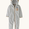 Patagonia little kids furry fiends bunting suit in crisp grey available at Babipur. A 100% recycled polyester thick fleece all in one in light grey with light brown trim and matching bear like ears on the hood. Features a full length zip, elasticated cuffs and a small chest pocket