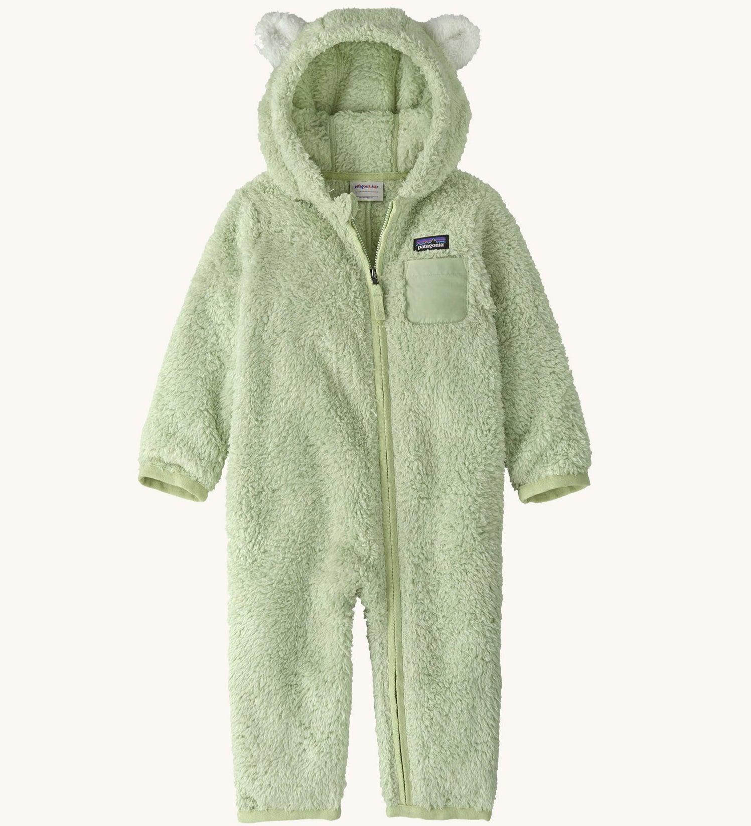 Patagonia little kids furry fiends bunting suit in lichen green available at Babipur. A 100% recycled polyester thick fleece all in one in pastel green with white bear like ears on the hood. Features a full length zip  , elasticated cuffs and a small chest pocket