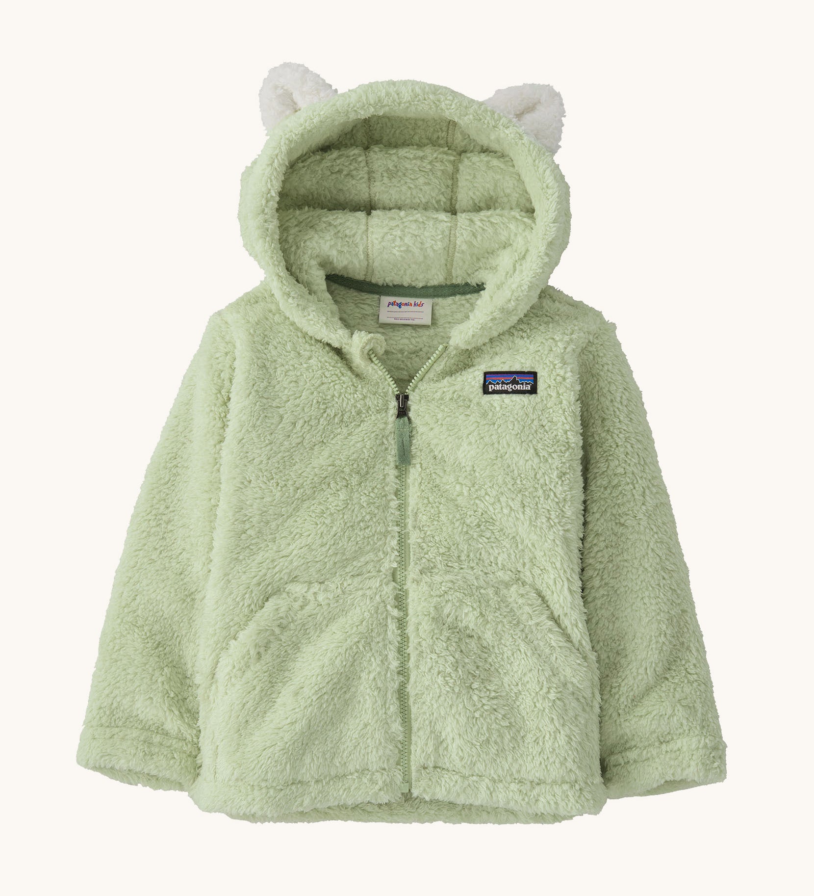Patagonia little kids furry friends hoody in lichen green available at Babipur. A 100% recycled polyester thick fleece hooded jacket in pale green with white bear like ears on the hood. Features a full length zip and 2 side pockets.