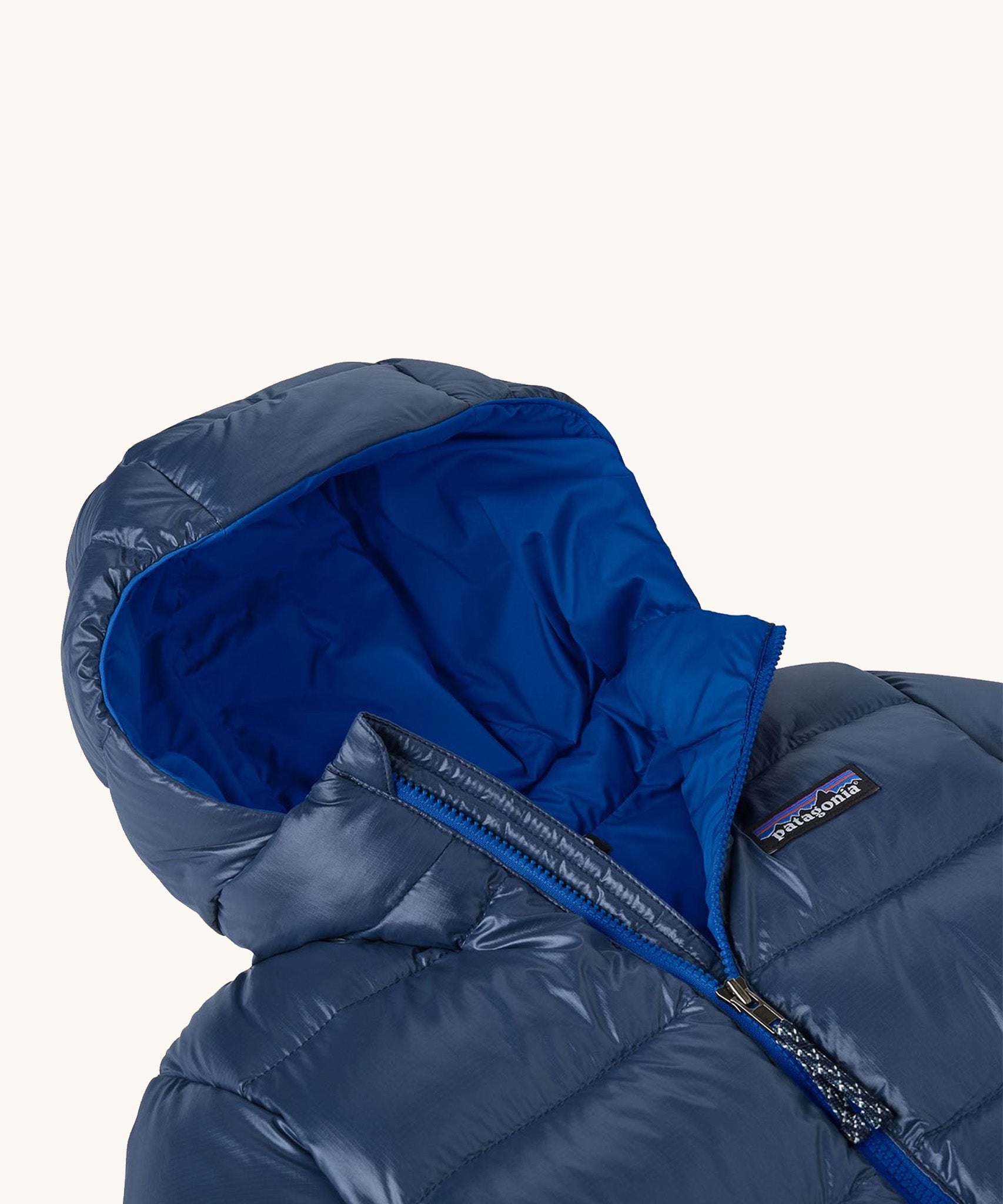 Patagonia little kids hi-loft down sweater hoody jacket in navy showing close up of the front zip detail and blue inner liner