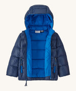 An open Patagonia little kids hi-loft down sweater hoody jacket in navy showing the blue inner and quilt through construction stitching. 