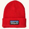 Patagonia little kids knitted beanie in sizzle red with brand patch on brim. Made from 100% recycled polyester yarn