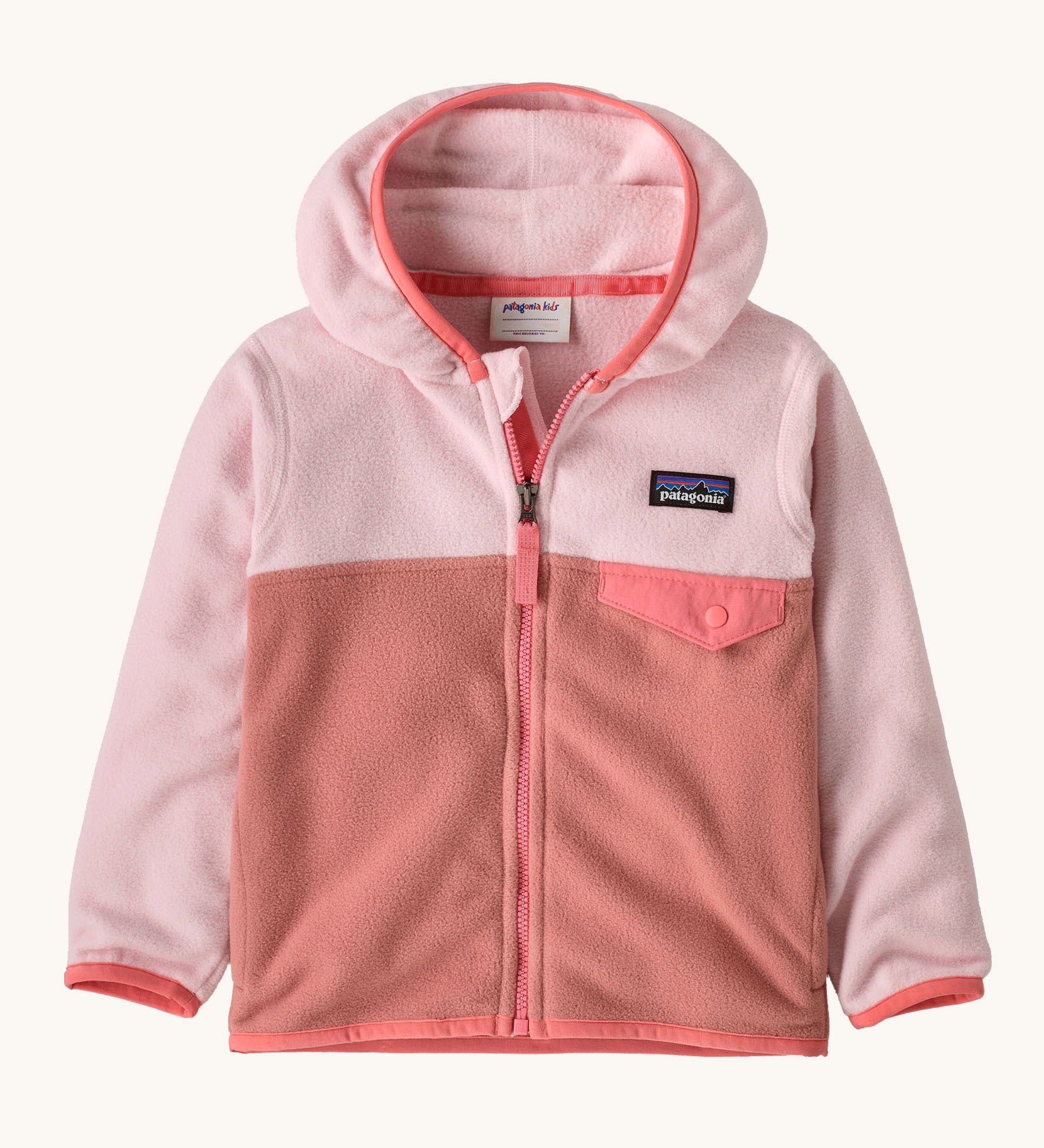 Patagonia little kids micro d snap t jacket in moment pink available at Babipur. A 100% recycled polyester soft fleece hooded jacket in light and dark pink with a matching trim. Features a full length zip and small chest pocket with a pink flap
