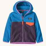 Patagonia little kids micro d snap t jacket in plummet purple available at Babipur. A 100% recycled polyester soft fleece hooded jacket in blue and purple with pink trim. Features a full length zip and small chest pocket with a orange flap