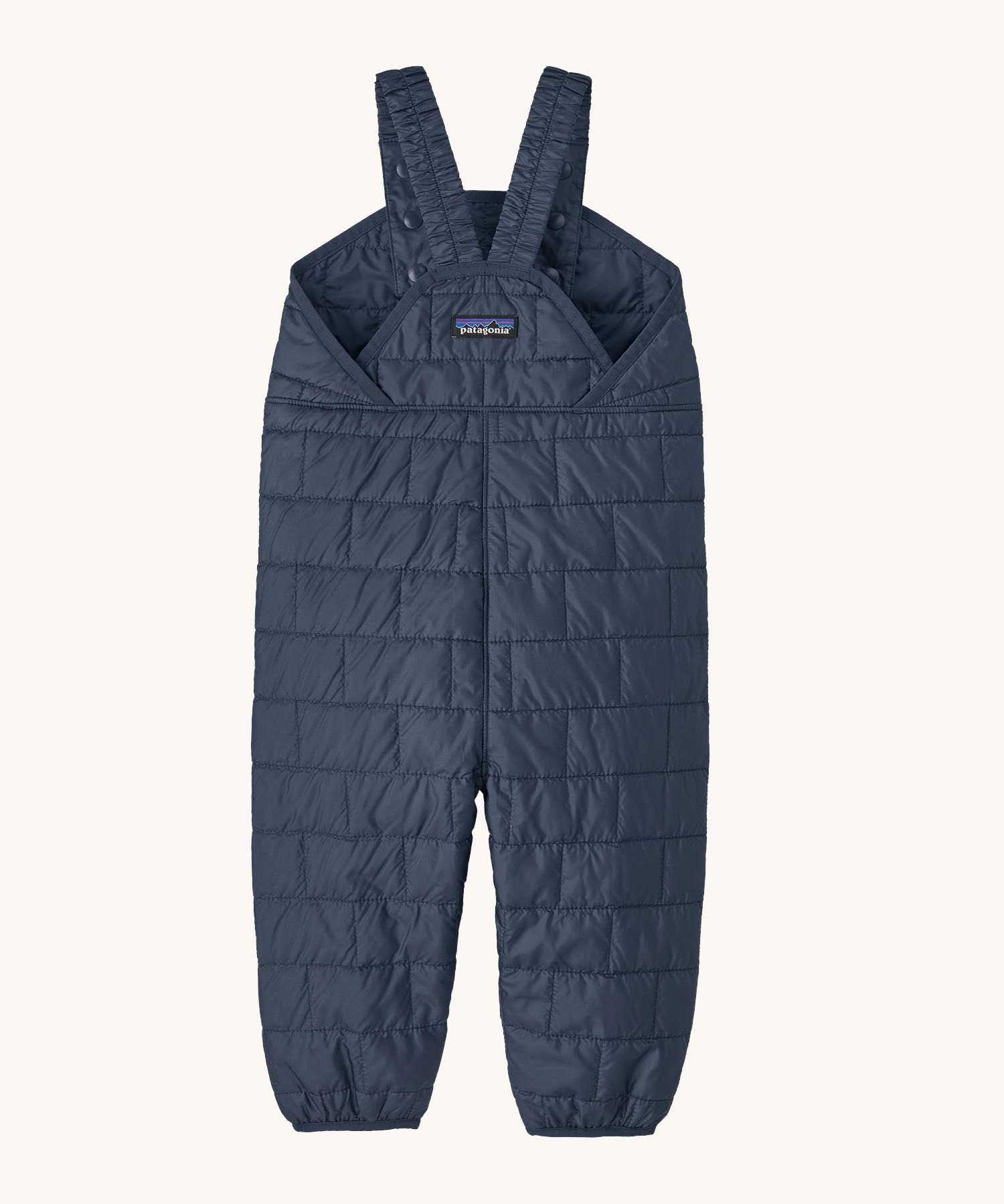 The back of the Patagonia kids nano puffer winter overalls in navy available at Babipur . Features popper fasteners on each shoulder strap for size adjustment. 