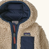Patagonia little kids retro x pile windproof hooded fleece jacket in beige with a navy inner showing close up the chest pocket and front zip