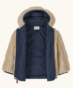 An open Patagonia little kids retro x pile windproof hooded fleece jacket in beige showing the navy inner liner
