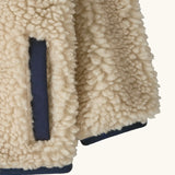 Patagonia little kids retro x pile windproof hooded fleece jacket in beige showing close up of the side pocket and cuff with navy trim