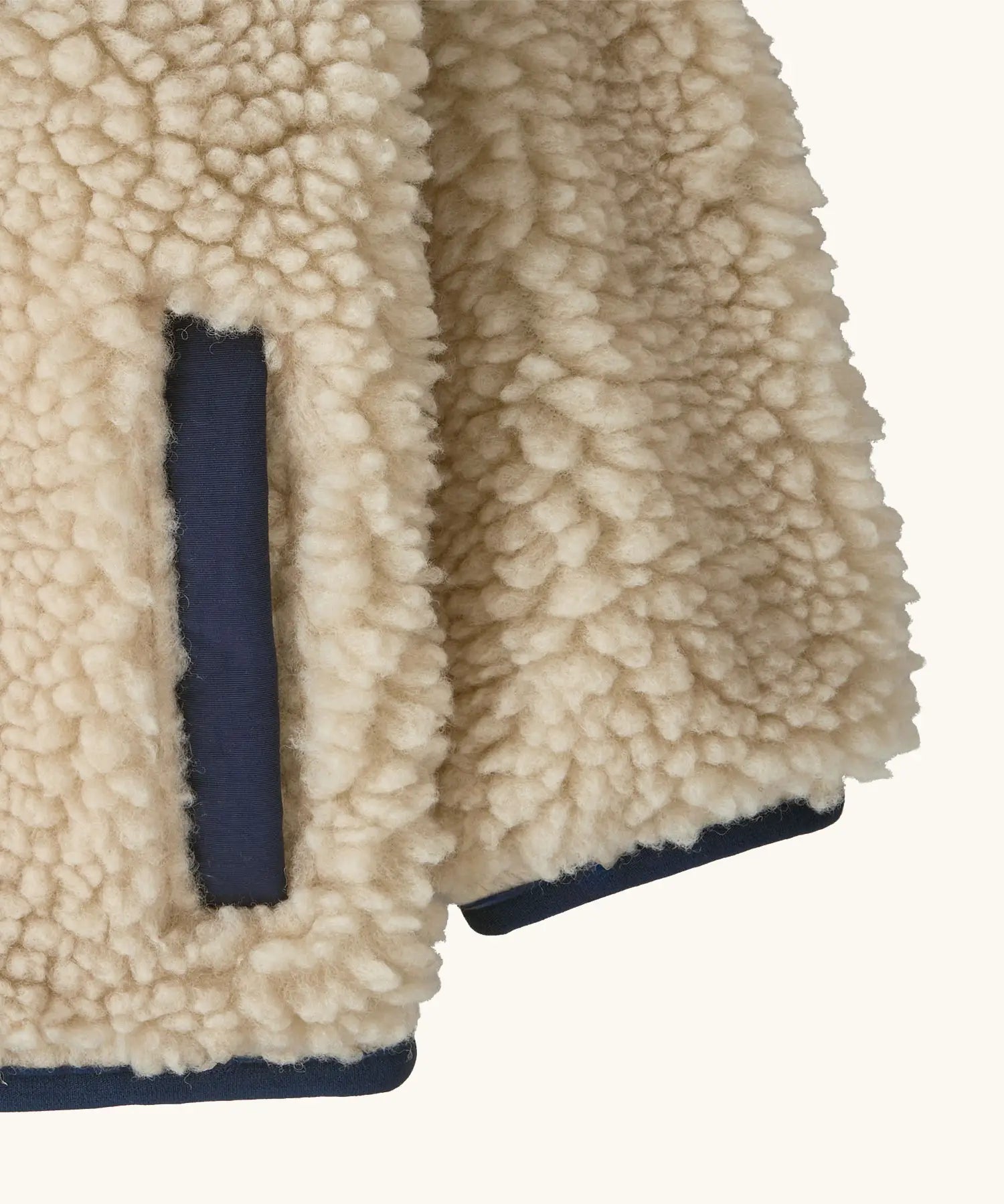 Patagonia little kids retro x pile windproof hooded fleece jacket in beige showing close up of the side pocket and cuff with navy trim