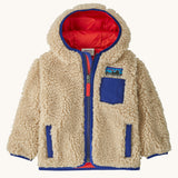 Patagonia little kids retro x hoody in dark natural available at Babipur. A 100% recycled polyester thick pile fleece hooded jacket in cream with blue trim Features a full length zip, 2 side pockets and a small chest pocket