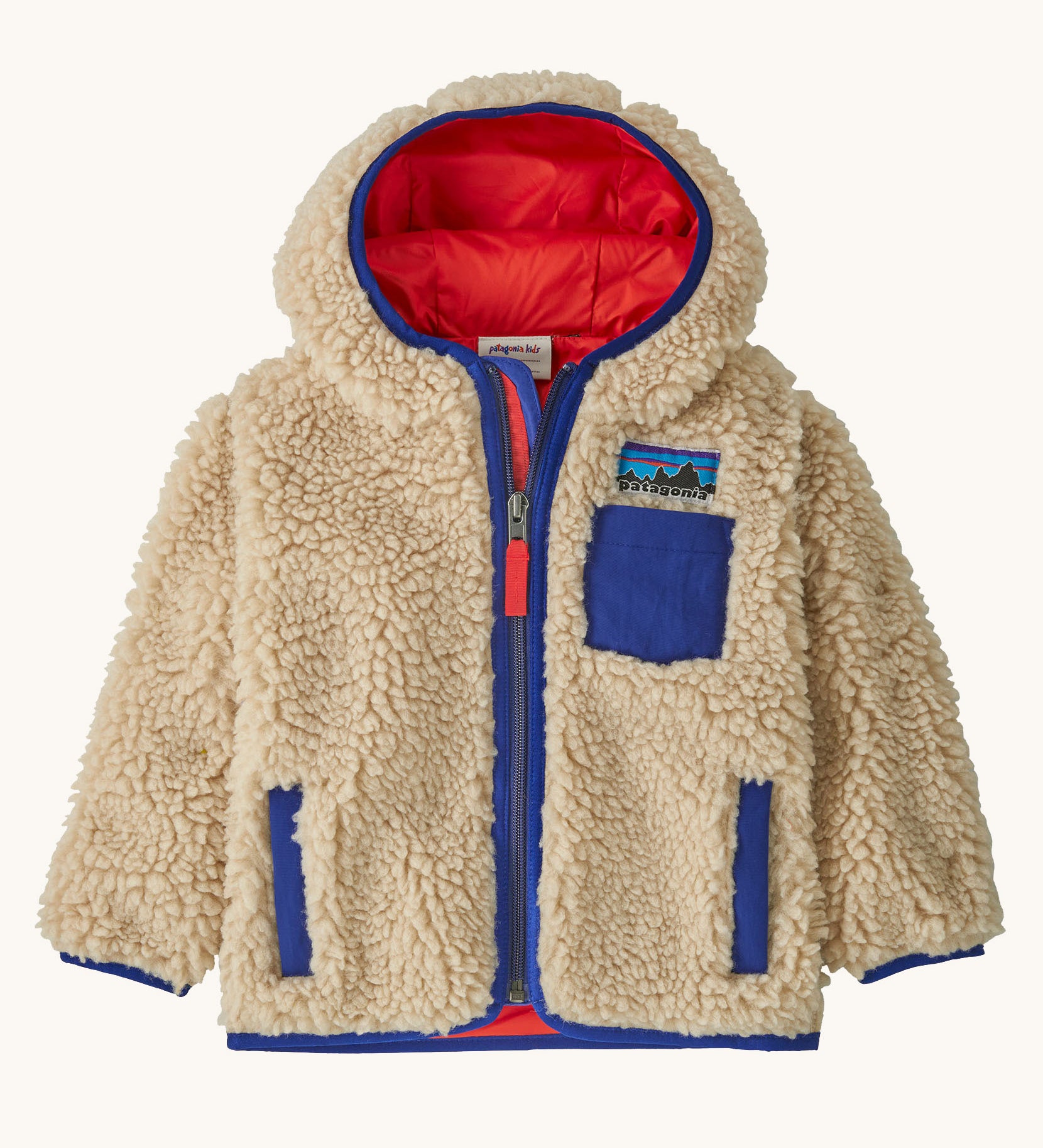 Patagonia little kids retro x hoody in dark natural available at Babipur. A 100% recycled polyester thick pile fleece hooded jacket in cream with blue trim Features a full length zip, 2 side pockets and a small chest pocket