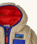 Patagonia little kids retro x pile fleece hooded jacket in beige showing a blue trim around the hood and top of the chest pocket