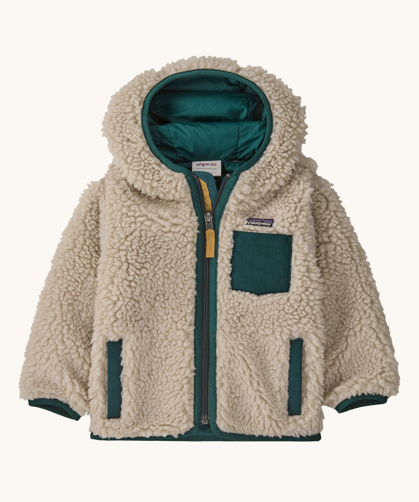 Patagonia little kids retro x hoody in dark natural /cascade green available at Babipur. A 100% recycled polyester thick pile fleece hooded jacket in cream with dark green trim Features a full length zip, 2 side pockets and a small chest pocket
