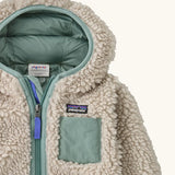 Patagonia little kids retro x pile windproof hooded fleece jacket in beige with a sage green inner showing close up of chest pocket and front zip