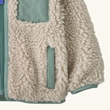 Patagonia little kids retro x pile windproof hooded fleece jacket in beige showing close up of the side pocket and cuff with sage green trim