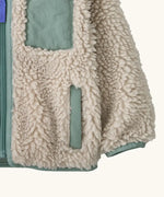 Patagonia little kids retro x pile windproof hooded fleece jacket in beige showing close up of the side pocket and cuff with sage green trim