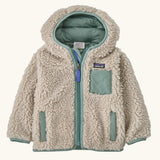 Patagonia little kids retro x pile windproof hooded fleece jacket in beige with a sage green inner. Shows a full front zip, side and chest pockets
