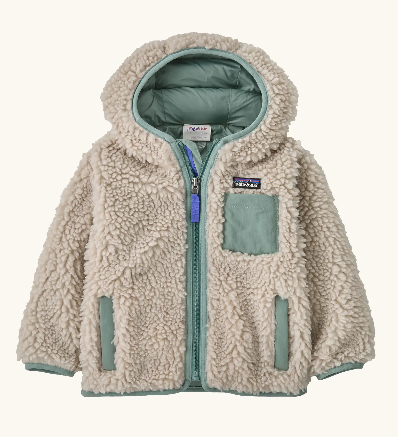 Patagonia little kids retro x pile windproof hooded fleece jacket in beige with a sage green inner. Shows a full front zip, side and chest pockets