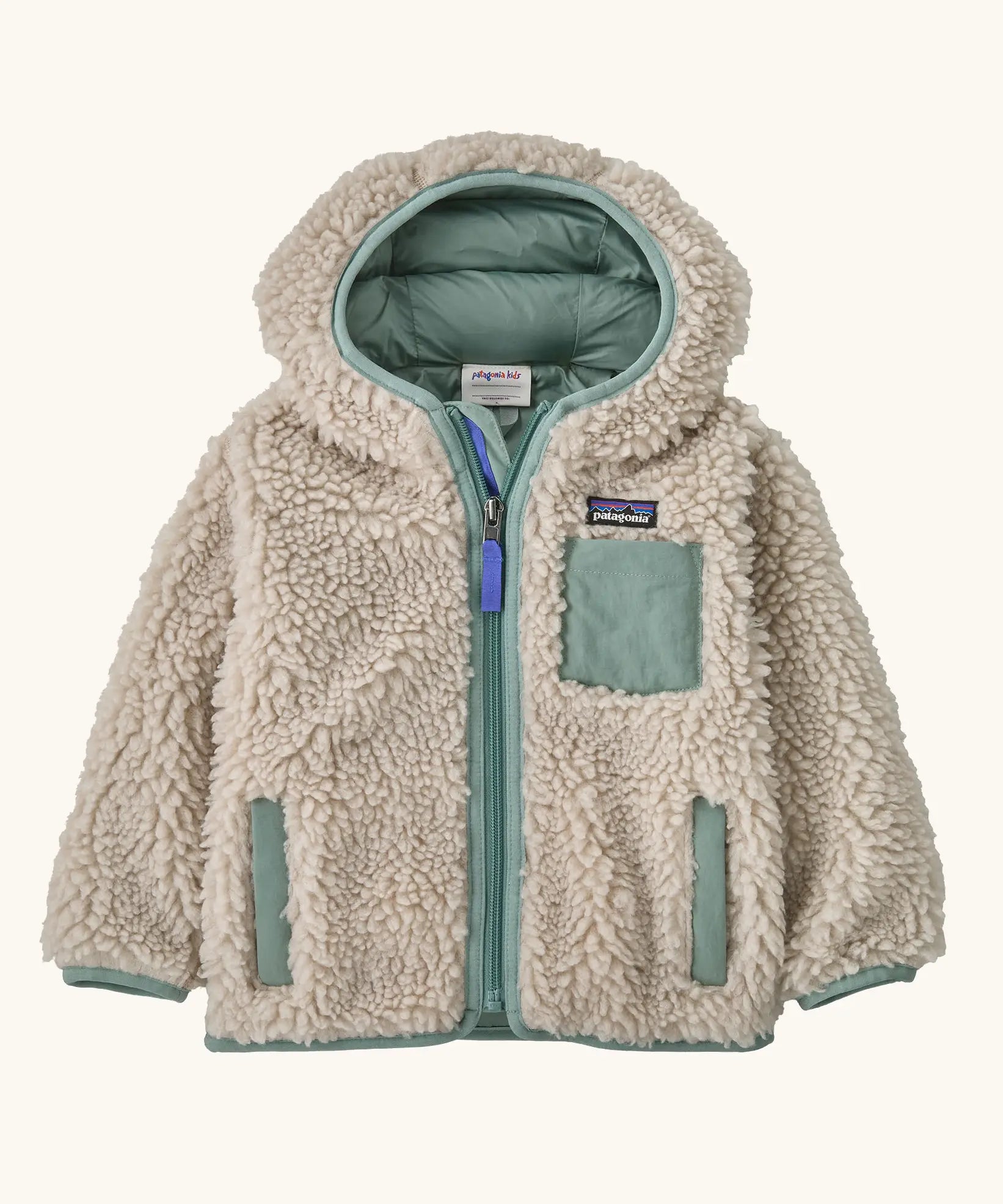 Patagonia little kids retro x pile windproof hooded fleece jacket in beige with a sage green inner. Shows a full front zip, side and chest pockets