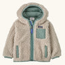 Patagonia little kids retro x pile windproof hooded fleece jacket in beige with a sage green inner. Shows a full front zip, side and chest pockets